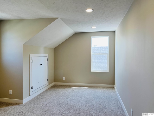 6916 N 24th St, Omaha, NE 68112 - additional living space featuring a textured ceiling, carpet flooring, baseboards, lofted ceiling, and recessed lighting