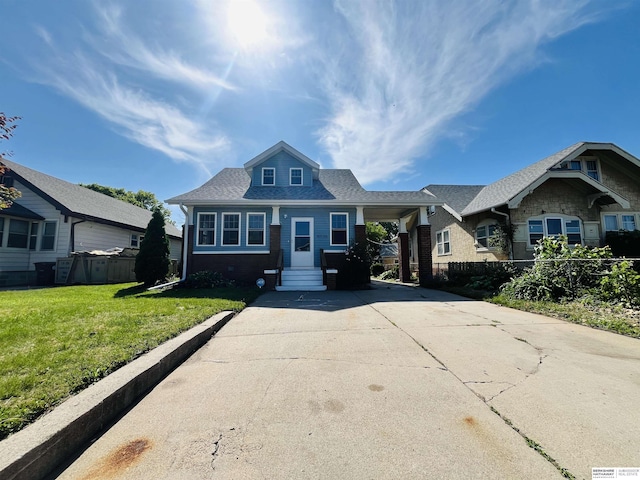 6916 N 24th St, Omaha, NE 68112 - bungalow-style house with concrete driveway, an attached carport, a shingled roof, and brick siding