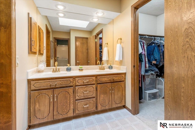926 Iron Rd, Papillion, NE 68046 - full bathroom with a skylight, double vanity, a walk in closet, and tile patterned floors