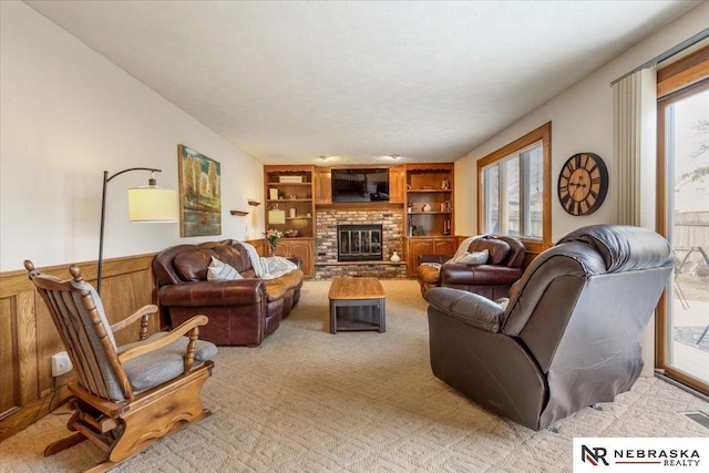 926 Iron Rd, Papillion, NE 68046 - living room featuring built in shelves, wainscoting, light carpet, a brick fireplace, and wood walls