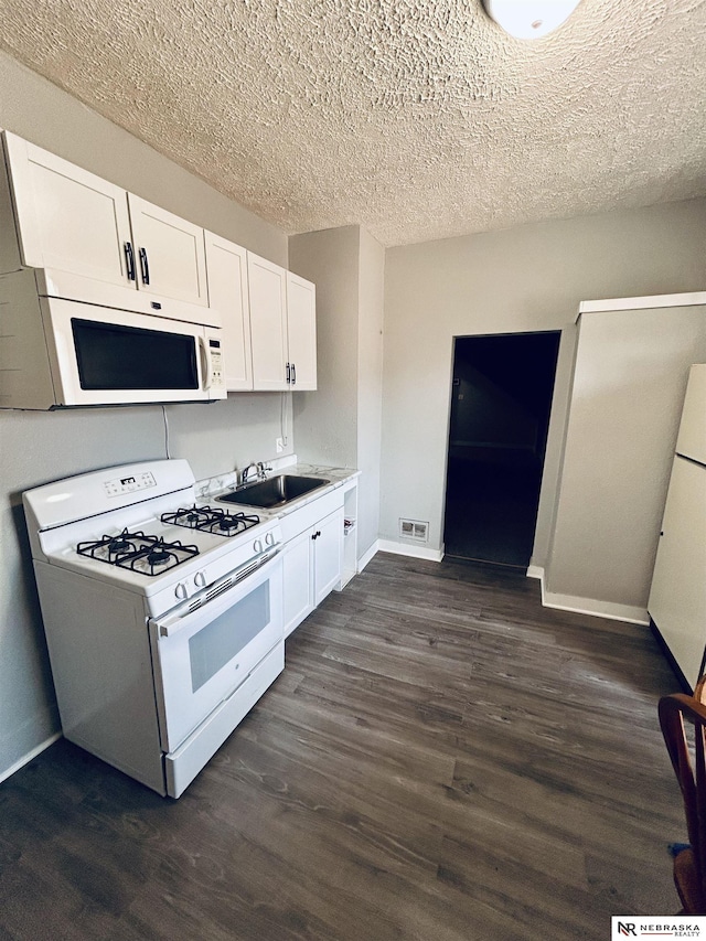 2413 Ohio St, Omaha, NE 68111 - kitchen with white appliances, a sink, white cabinets, dark wood-type flooring, and light countertops