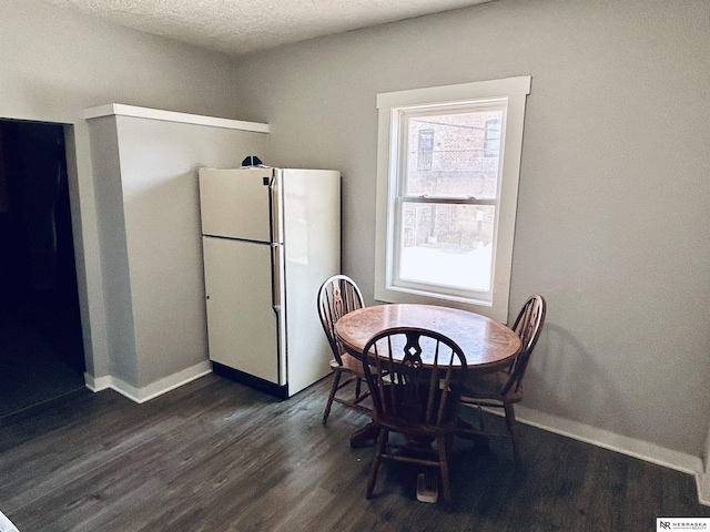 2413 Ohio St, Omaha, NE 68111 - dining room featuring dark wood-style flooring, baseboards, and a textured ceiling