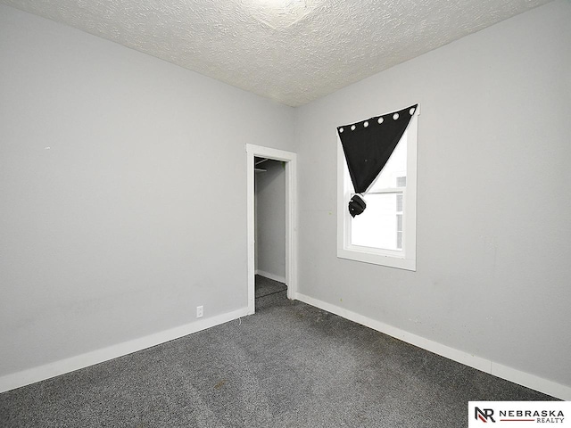 2413 Ohio St, Omaha, NE 68111 - spare room featuring dark colored carpet, baseboards, and a textured ceiling