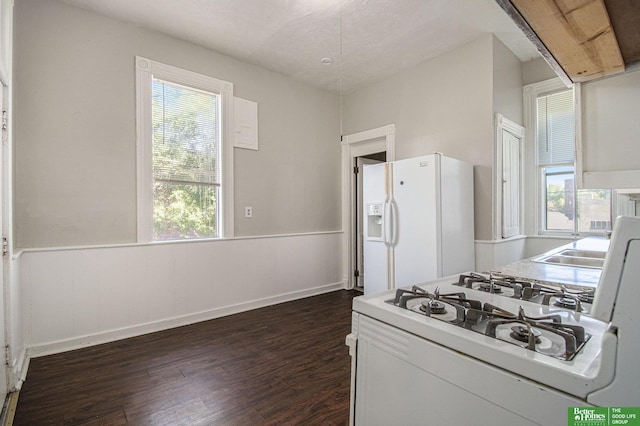 1320 N 40th St, Omaha, NE 68131 - kitchen with white appliances, dark wood-style flooring, a wainscoted wall, light countertops, and a sink