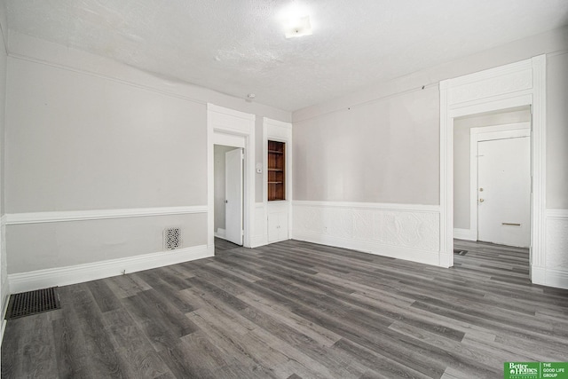 1320 N 40th St, Omaha, NE 68131 - spare room featuring wood finished floors, a textured ceiling, and wainscoting
