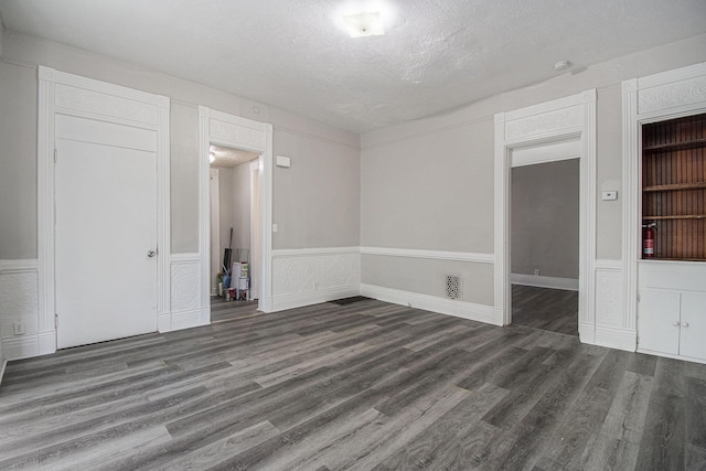 1320 N 40th St, Omaha, NE 68131 - unfurnished room with wood finished floors, a textured ceiling, a wainscoted wall, and a decorative wall