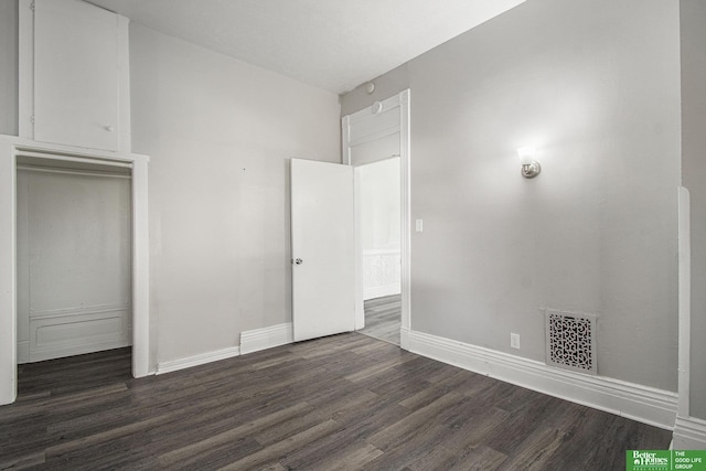 1320 N 40th St, Omaha, NE 68131 - unfurnished bedroom featuring dark wood-style flooring, baseboards, and a closet