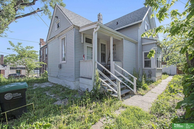 1320 N 40th St, Omaha, NE 68131 - view of front of house featuring a porch, a chimney, a shingled roof, and stairway