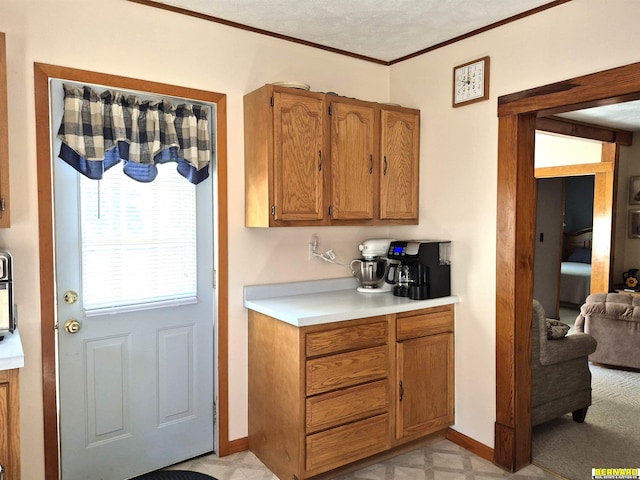 1112 10th St, Auburn, NE 68305 - kitchen with light countertops, ornamental molding, baseboards, and brown cabinetry