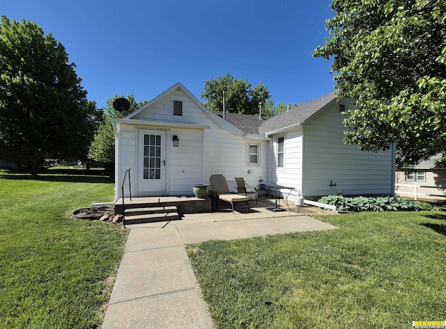 1112 10th St, Auburn, NE 68305 - back of property featuring a yard, a patio area, and a shingled roof