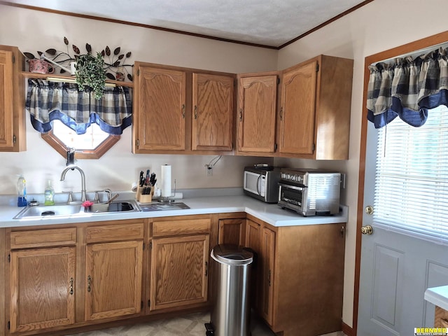 1112 10th St, Auburn, NE 68305 - kitchen with a sink, light countertops, stainless steel microwave, crown molding, and brown cabinets
