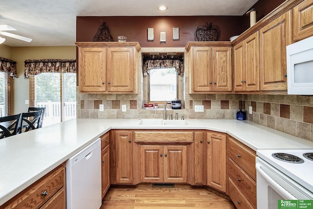 8112 Molokai Dr, Papillion, NE 68046 - kitchen featuring white appliances, a sink, light wood finished floors, ceiling fan, and tasteful backsplash