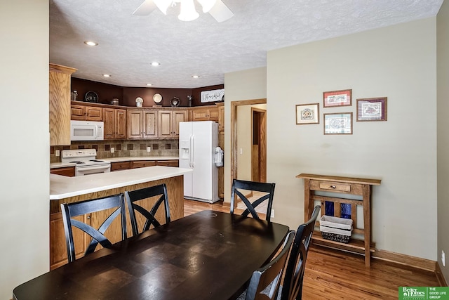8112 Molokai Dr, Papillion, NE 68046 - dining room with a ceiling fan, light wood finished floors, a textured ceiling, recessed lighting, and baseboards