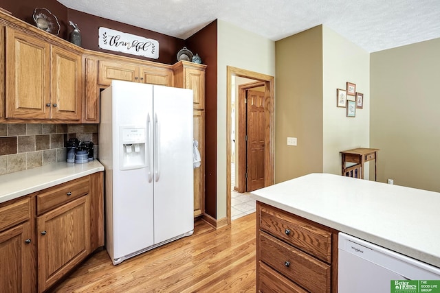 8112 Molokai Dr, Papillion, NE 68046 - kitchen with white appliances, light wood-style flooring, tasteful backsplash, light countertops, and brown cabinetry