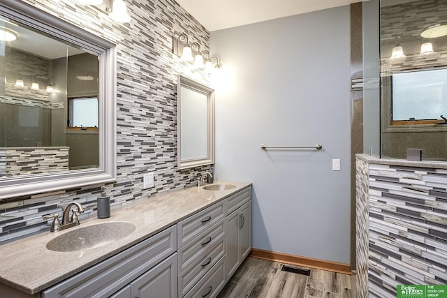 8112 Molokai Dr, Papillion, NE 68046 - bathroom with double vanity, backsplash, wood finished floors, baseboards, and a shower