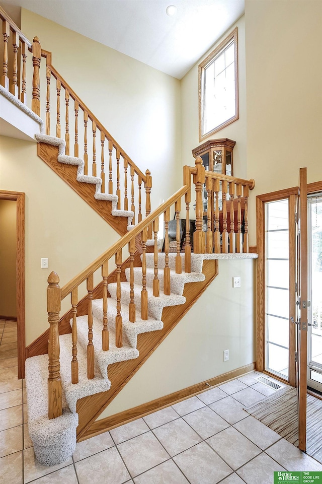 8112 Molokai Dr, Papillion, NE 68046 - staircase featuring a high ceiling, baseboards, tile patterned flooring, and french doors