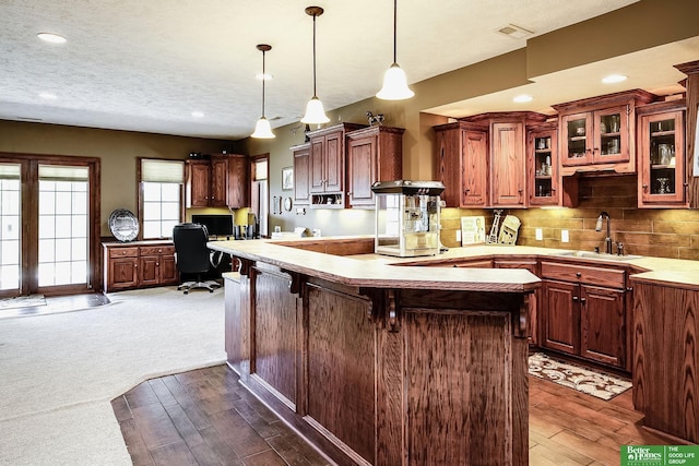 8112 Molokai Dr, Papillion, NE 68046 - kitchen with a sink, decorative light fixtures, glass insert cabinets, decorative backsplash, and dark wood-style floors