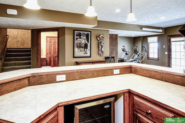 8112 Molokai Dr, Papillion, NE 68046 - bar featuring beverage cooler, a textured ceiling, pendant lighting, and stairs