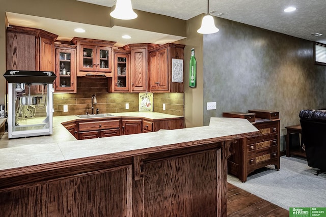 8112 Molokai Dr, Papillion, NE 68046 - kitchen with a sink, light countertops, dark wood-style flooring, tasteful backsplash, and glass insert cabinets