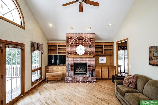 8112 Molokai Dr, Papillion, NE 68046 - living room with high vaulted ceiling, light wood finished floors, a fireplace, a ceiling fan, and recessed lighting