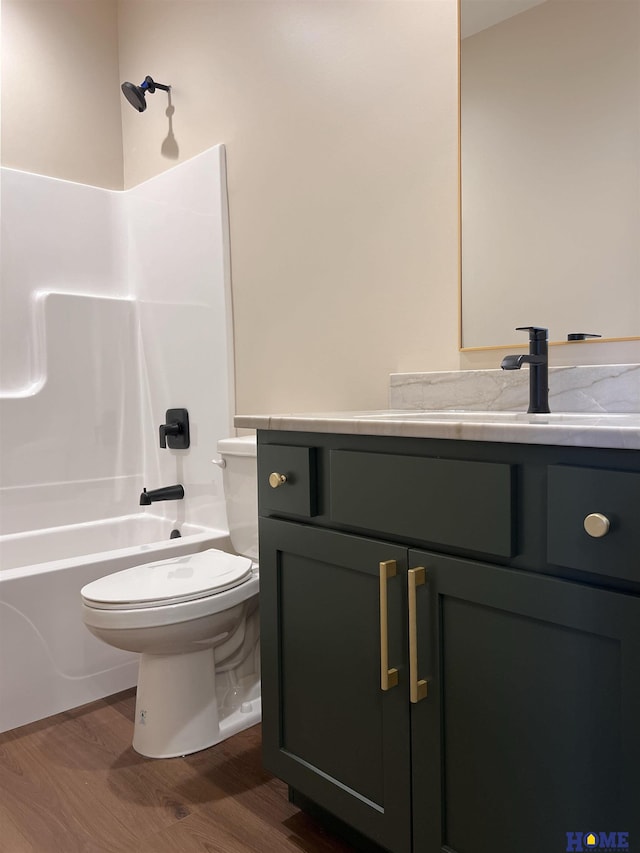 900 Middleton Ave, Lincoln, NE 68521 - bathroom with toilet, wood finished floors, vanity, and tub / shower combination