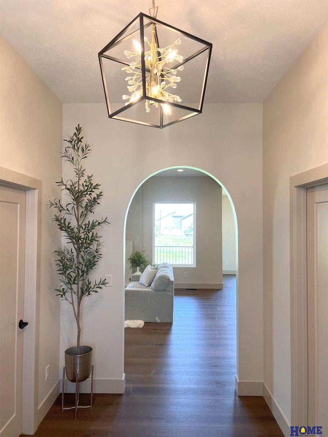 900 Middleton Ave, Lincoln, NE 68521 - hallway featuring arched walkways, wood finished floors, baseboards, and a chandelier
