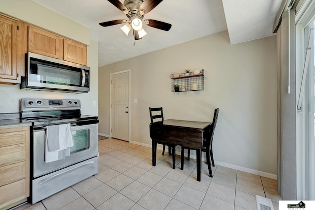 1206 W Ryons St, Lincoln, NE 68522 - kitchen featuring stainless steel appliances, light tile patterned floors, ceiling fan, and baseboards