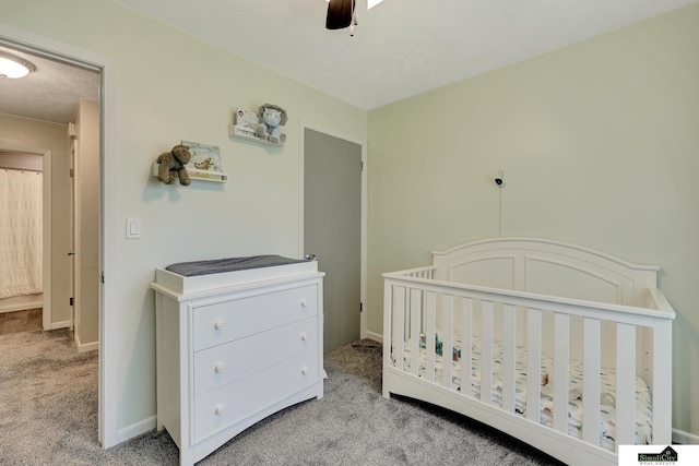 1206 W Ryons St, Lincoln, NE 68522 - carpeted bedroom featuring a crib, baseboards, and ceiling fan