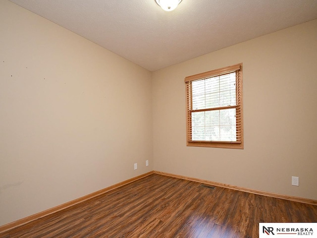 1853 SW 38th St, Lincoln, NE 68522 - spare room featuring dark wood-type flooring and baseboards