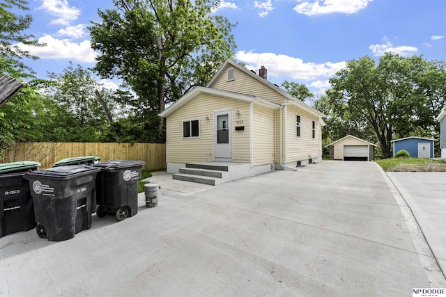 5435 S 18th St, Omaha, NE 68107 - view of front of property with an outdoor structure, a detached garage, and a chimney