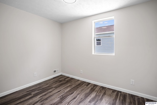 5435 S 18th St, Omaha, NE 68107 - empty room featuring dark wood-type flooring, baseboards, and a textured ceiling
