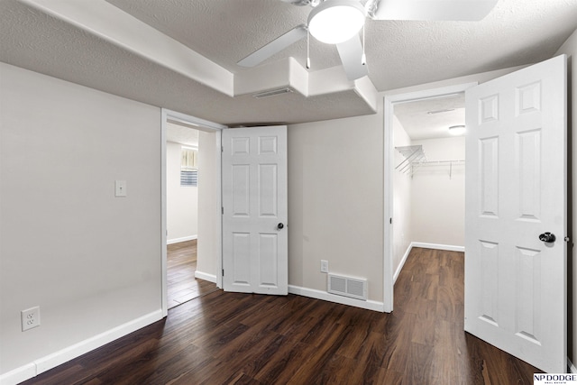 5435 S 18th St, Omaha, NE 68107 - unfurnished bedroom featuring dark wood-style floors, baseboards, a spacious closet, a textured ceiling, and a closet