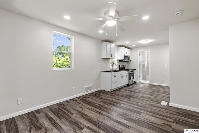 5435 S 18th St, Omaha, NE 68107 - kitchen featuring appliances with stainless steel finishes, dark countertops, a ceiling fan, baseboards, and dark wood finished floors