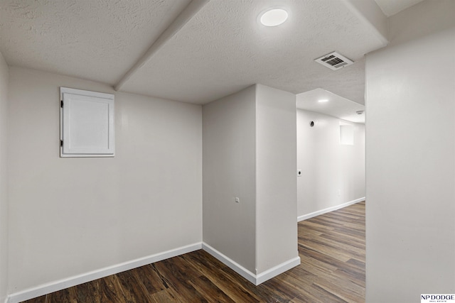5437 S 18th St, Omaha, NE 68107 - finished below grade area featuring a textured ceiling, dark wood finished floors, and baseboards