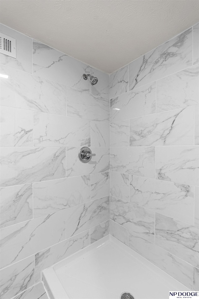 5437 S 18th St, Omaha, NE 68107 - bathroom with a tile shower and a textured ceiling
