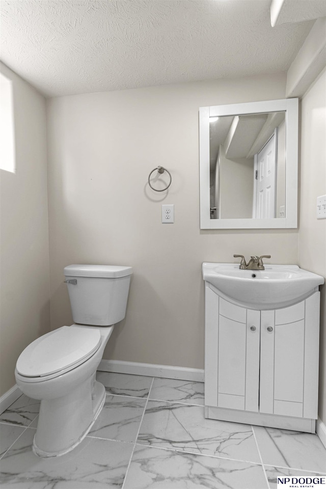 5437 S 18th St, Omaha, NE 68107 - bathroom with marble finish flooring, toilet, vanity, baseboards, and a textured ceiling