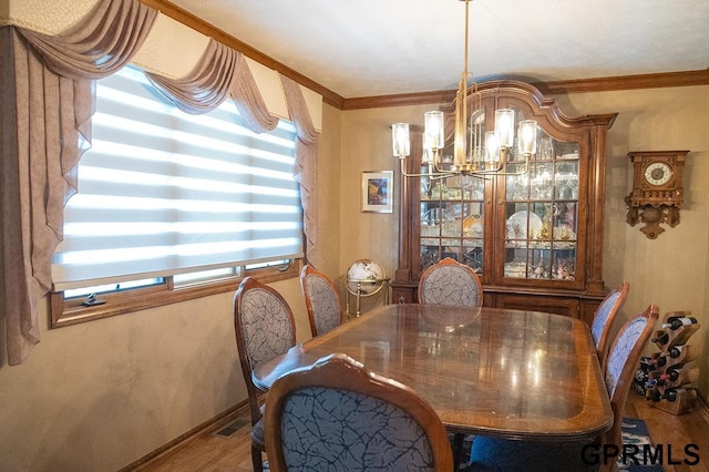 10755 Berry Plz, Omaha, NE 68127 - dining area with wood finished floors, a chandelier, ornamental molding, and baseboards