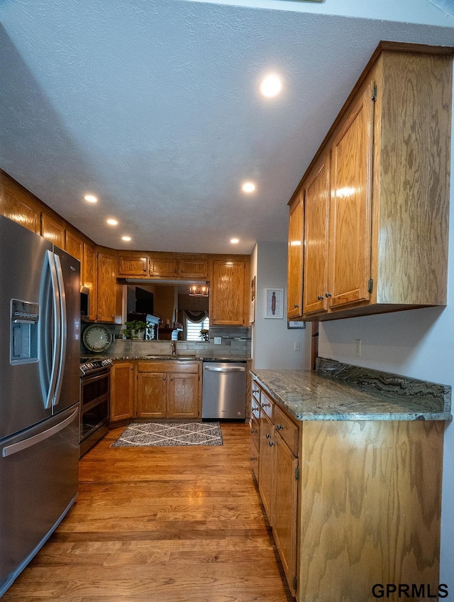 10755 Berry Plz, Omaha, NE 68127 - kitchen featuring stainless steel appliances, brown cabinetry, wood finished floors, and recessed lighting