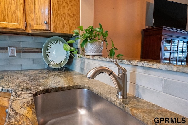 10755 Berry Plz, Omaha, NE 68127 - detailed view of tasteful backsplash, brown cabinets, and a sink