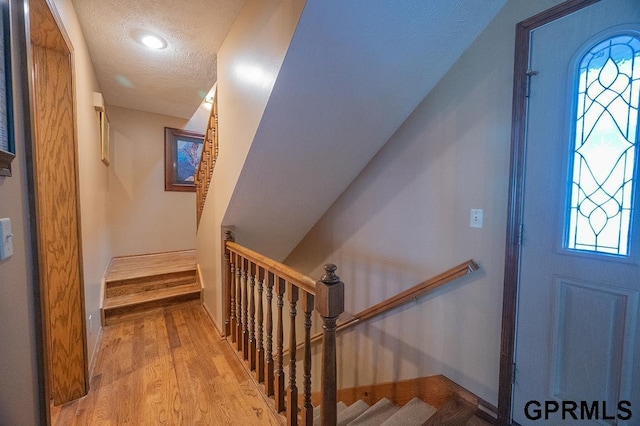 10755 Berry Plz, Omaha, NE 68127 - entryway with wood finished floors, a textured ceiling, and baseboards
