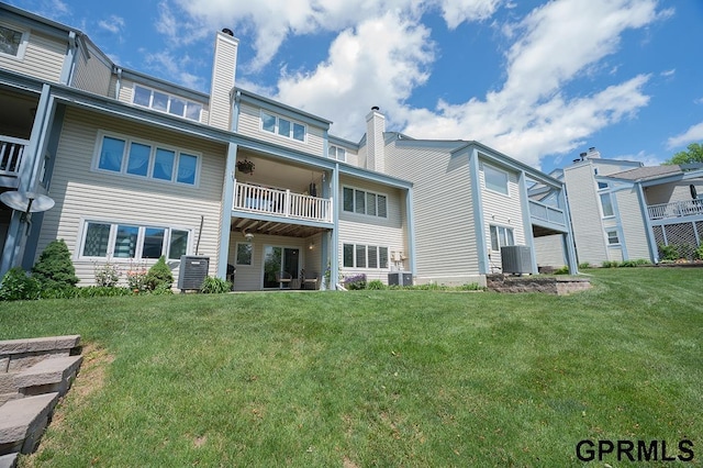 10755 Berry Plz, Omaha, NE 68127 - back of property featuring a lawn, cooling unit, a chimney, and a balcony