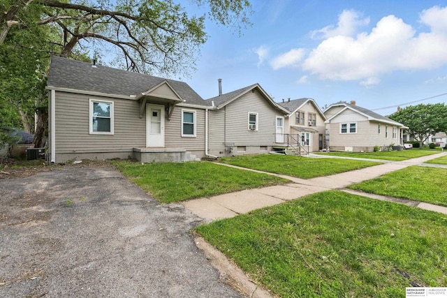 1152 N D St, Fremont, NE 68025 - view of front of home with cooling unit, a front yard, and a shingled roof