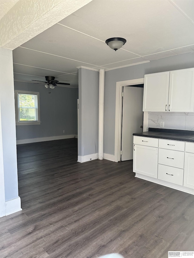 1152 N D St, Fremont, NE 68025 - kitchen with baseboards, dark countertops, white cabinetry, and dark wood-style floors