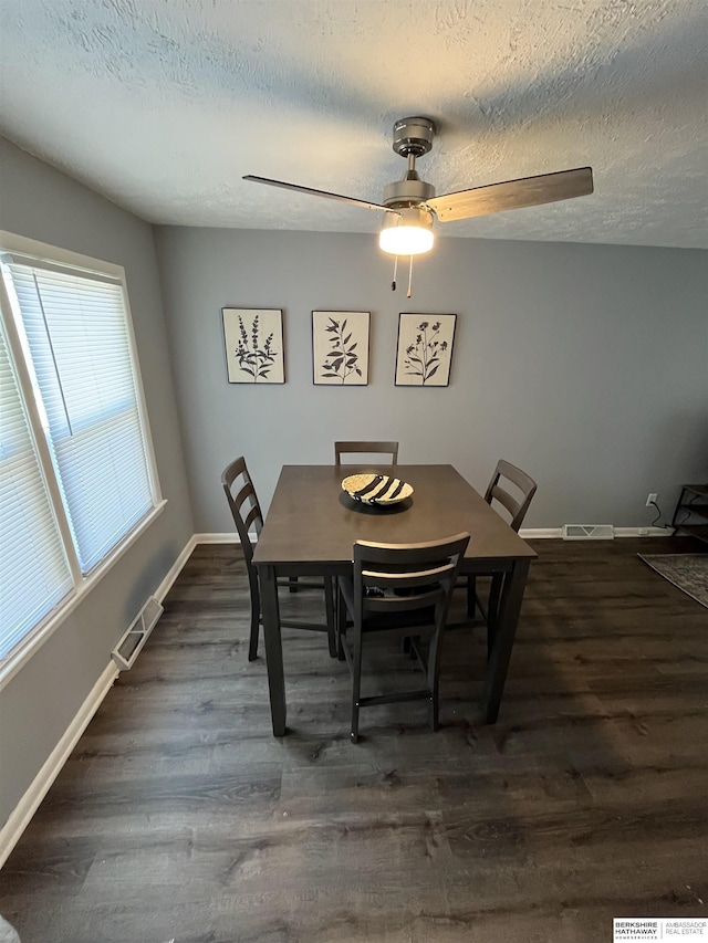 1152 N D St, Fremont, NE 68025 - dining room with dark wood-style floors, a textured ceiling, baseboards, and ceiling fan