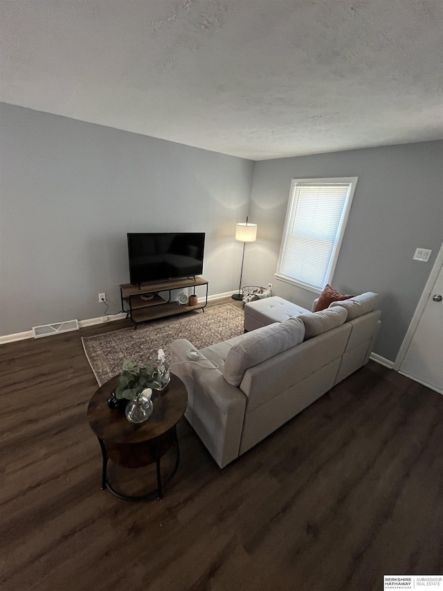 1152 N D St, Fremont, NE 68025 - living area featuring dark wood-style flooring, baseboards, and a textured ceiling