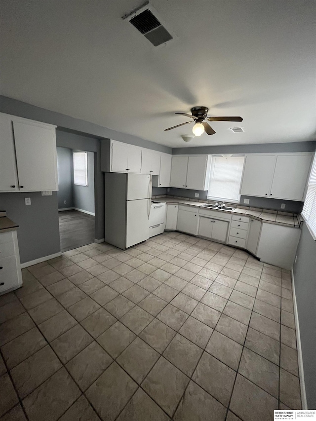 1152 N D St, Fremont, NE 68025 - kitchen with white appliances, ceiling fan, tile patterned floors, a sink, and baseboards