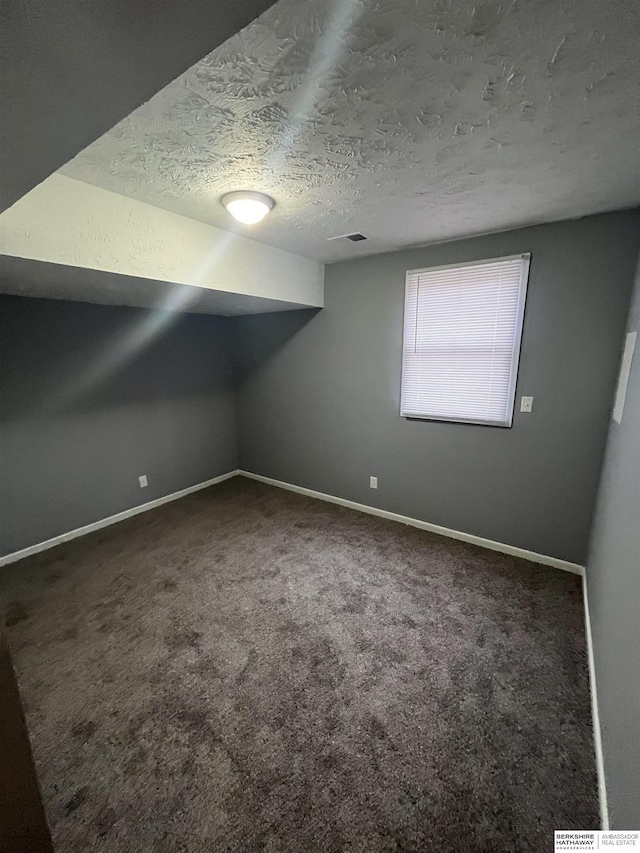 1152 N D St, Fremont, NE 68025 - bonus room featuring a textured ceiling, carpet flooring, and baseboards