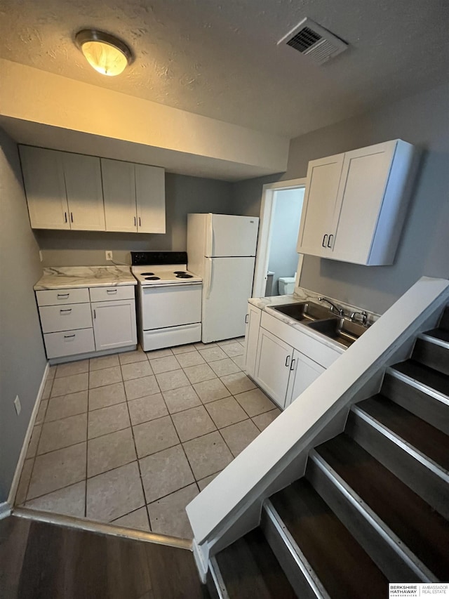 1152 N D St, Fremont, NE 68025 - kitchen with white appliances, a sink, baseboards, white cabinetry, and light countertops