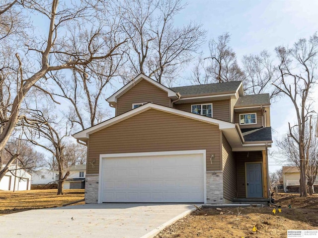 5441 S 51st St, Omaha, NE 68117 - view of front of property with concrete driveway, stone siding, and an attached garage
