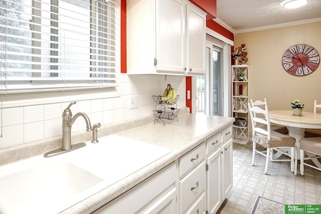 7535 S 76th St, La Vista, NE 68128 - kitchen with ornamental molding, a sink, white cabinetry, backsplash, and light countertops